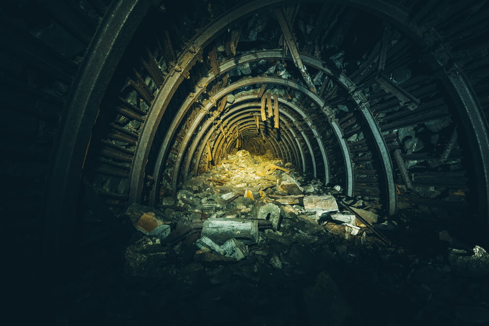 a tunnel filled with rubble next to a pile of rubble