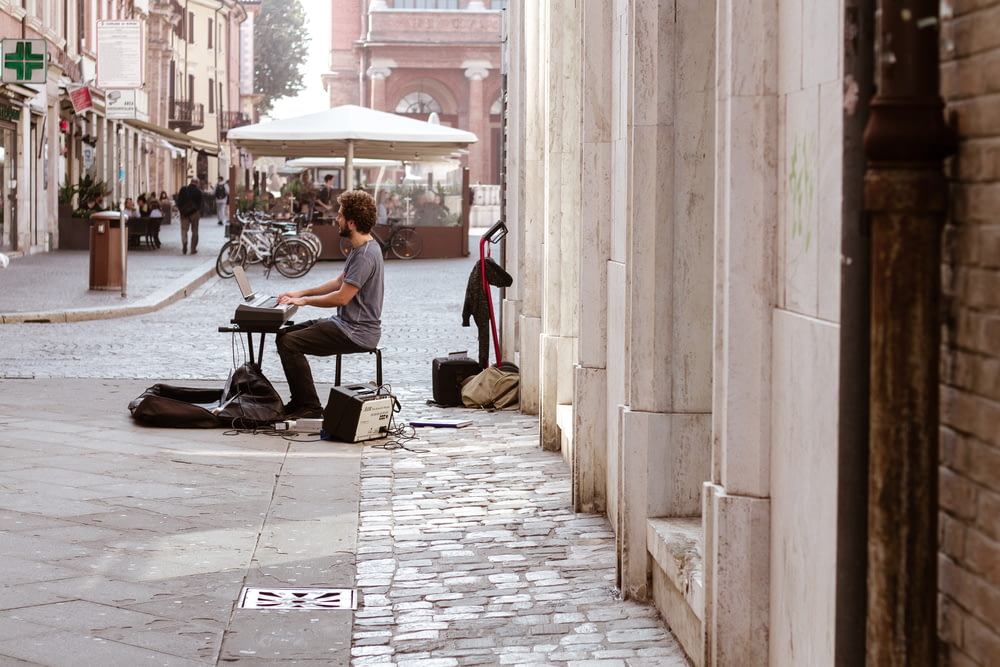 man playing keyboard on sidewalk