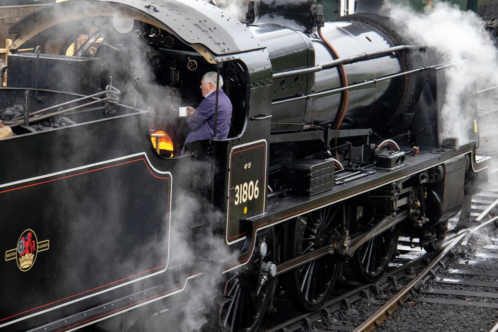 man standing inside steam train