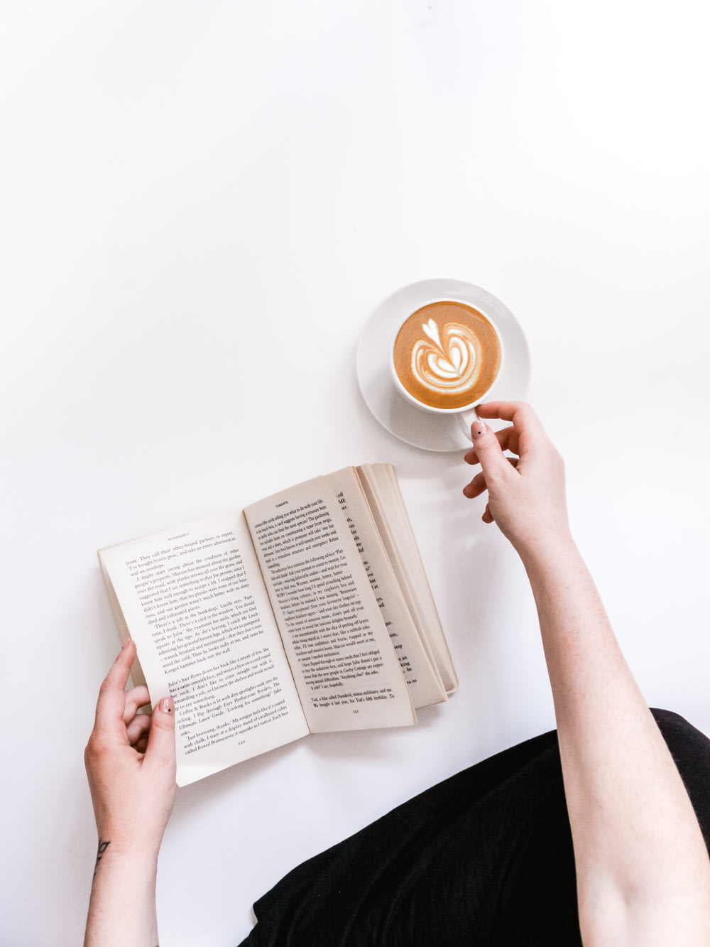 opened book and coffee on white surface