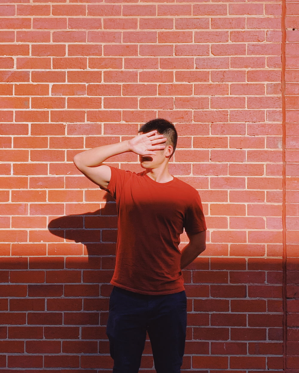 man standing in front of brick wall