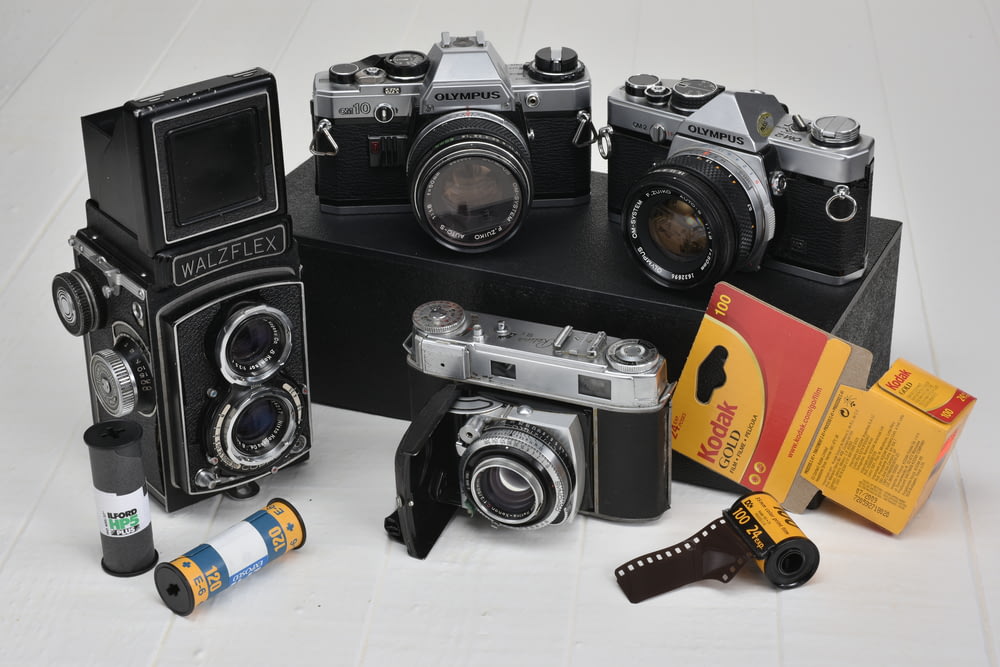 Quattro fotocamere classiche grigie e nere con rullini