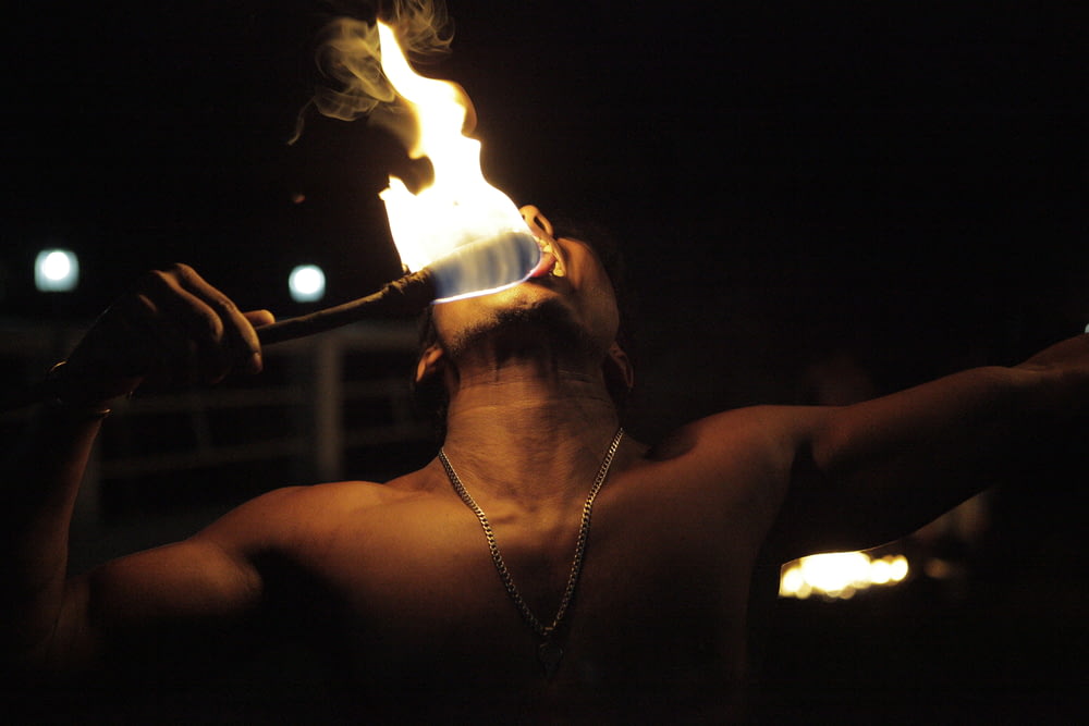man playing fire in dim light