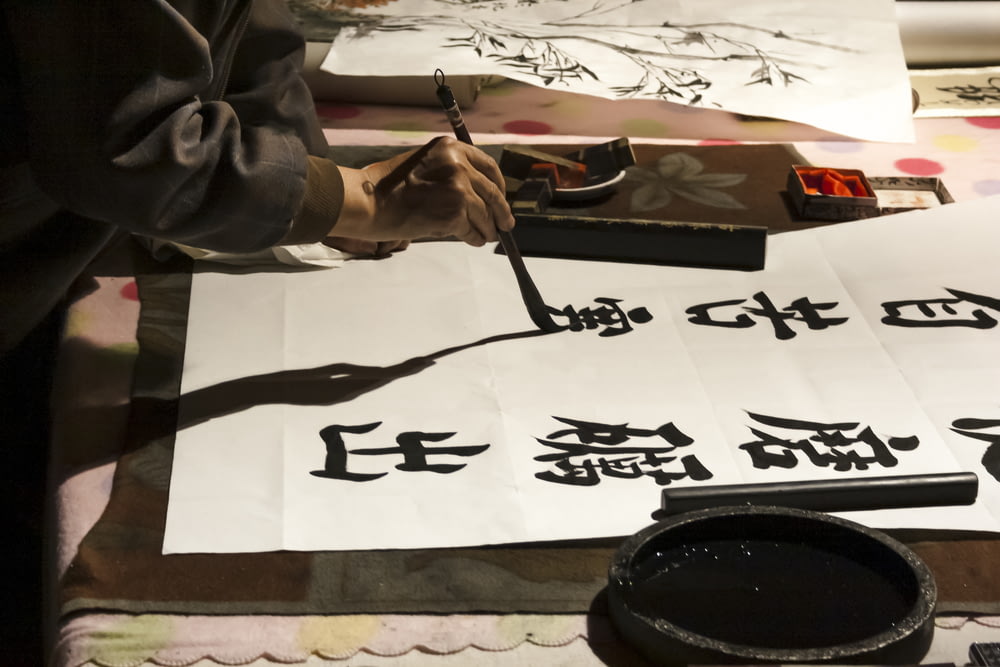 personne faisant de la calligraphie kanji