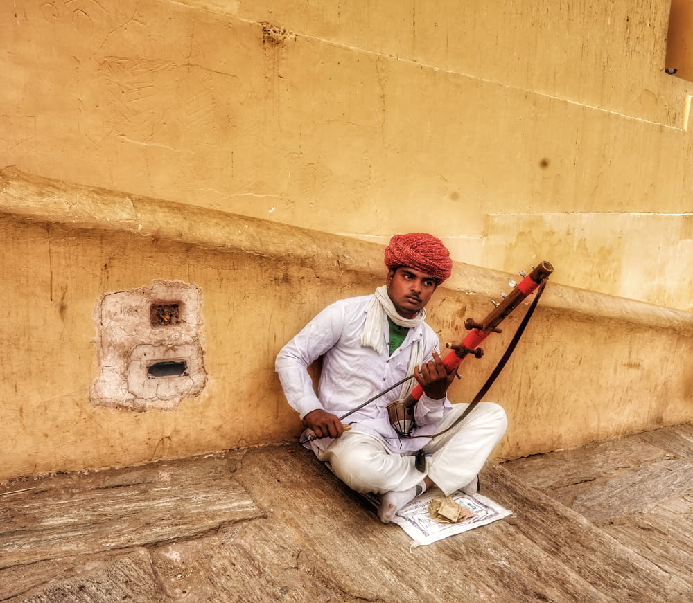 man sitting and holding string instrument
