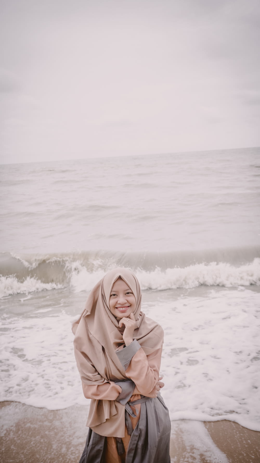 Frau mit braunem Hijab am Meeresufer