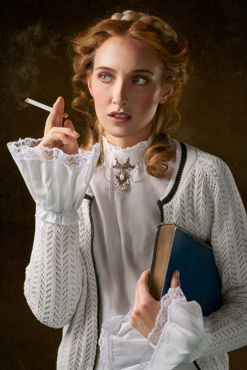 mulher com cigarro segurando foto do livro