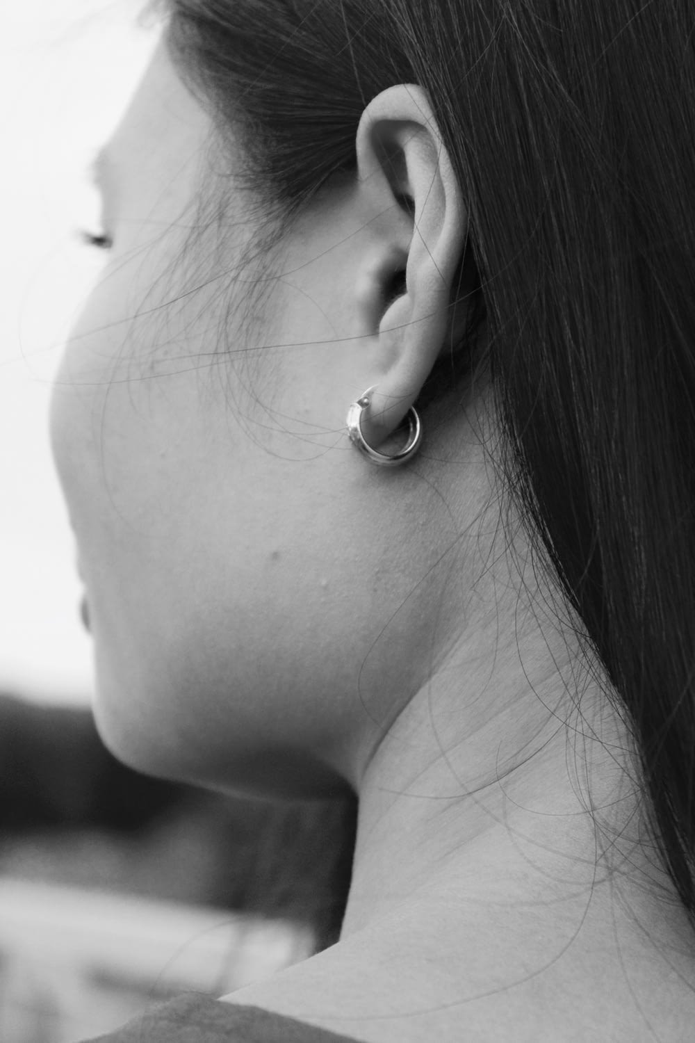 Photographie en niveaux de gris d’une femme portant une boucle d’oreille créole