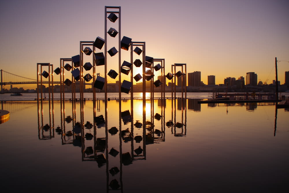 panoramic photography of buildings and towers reflecting on body of water during sunset