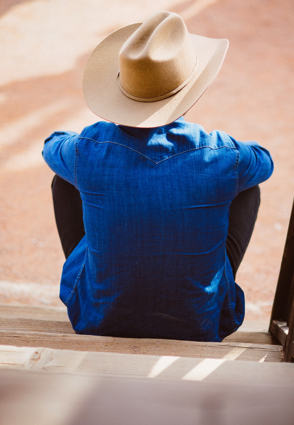 Mann mit blauem Hemd und beigefarbenem Cowboyhut