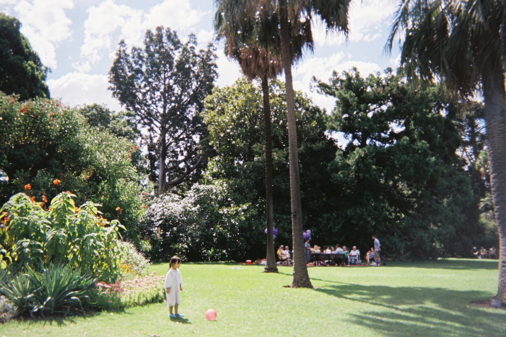 Menina em pé perto de palmeiras