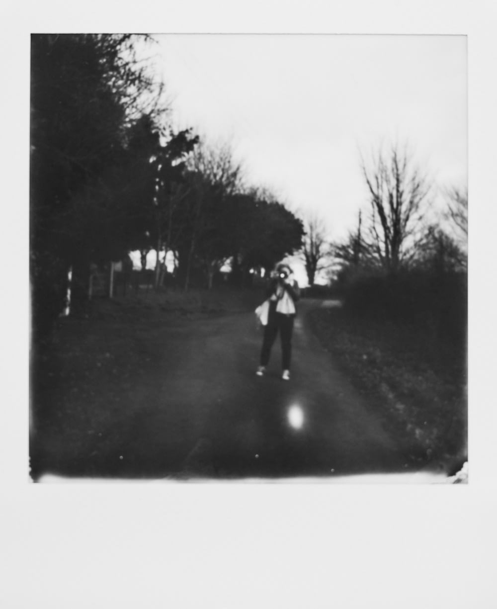 grayscale photo of 2 person walking on road
