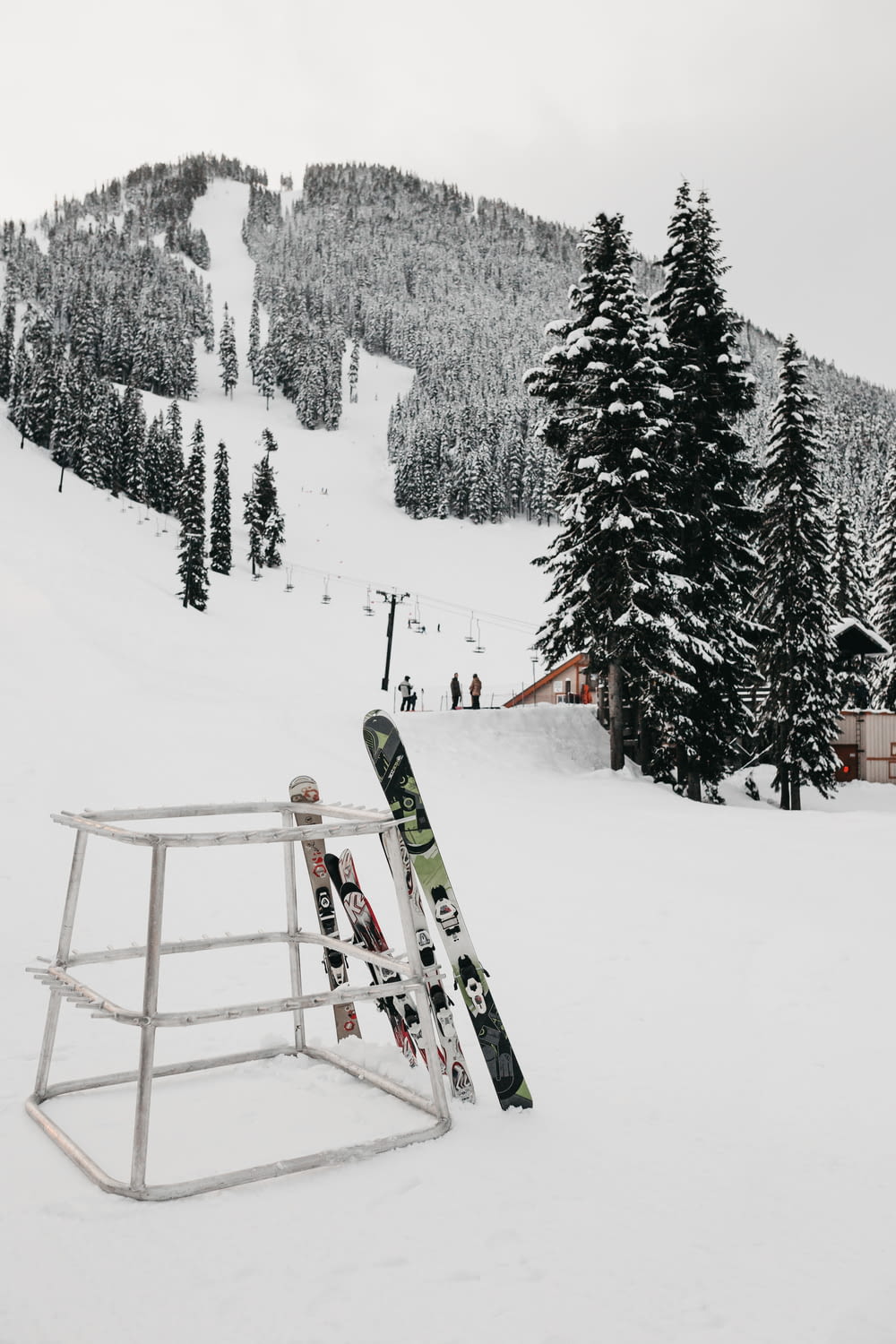 2 pairs of ski on metal stand on mountain slope