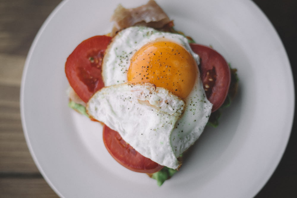 fried egg with black pepper and sliced tomatoes