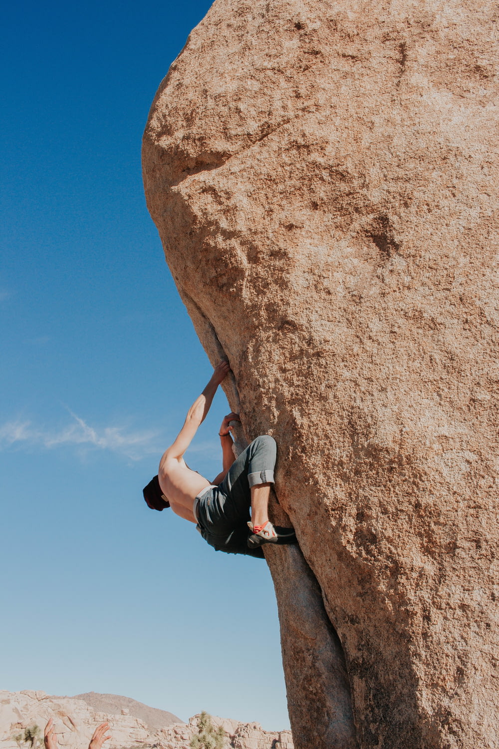 man climbing brown rock