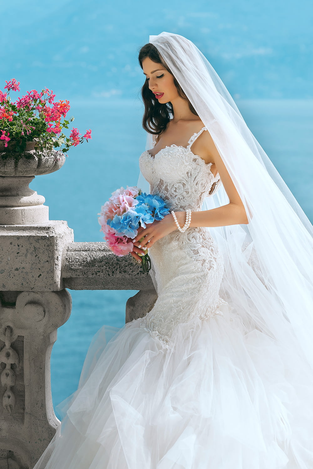 Mujer en vestido de novia mientras sostiene la flor durante el día