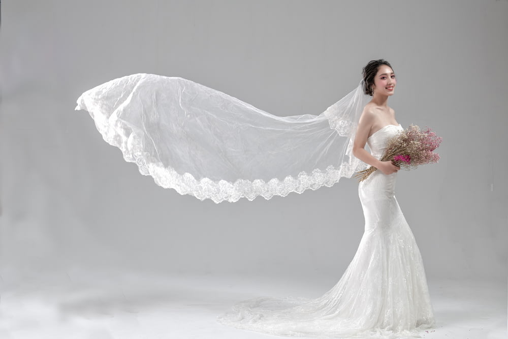 woman wearing white wedding dress holding flower bouquet