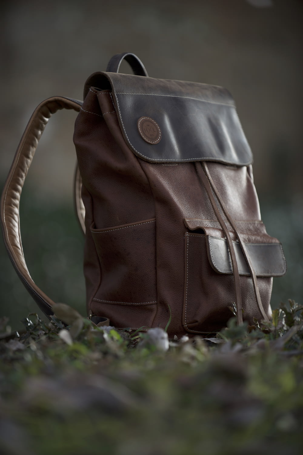 brown and black leather backpack on ground