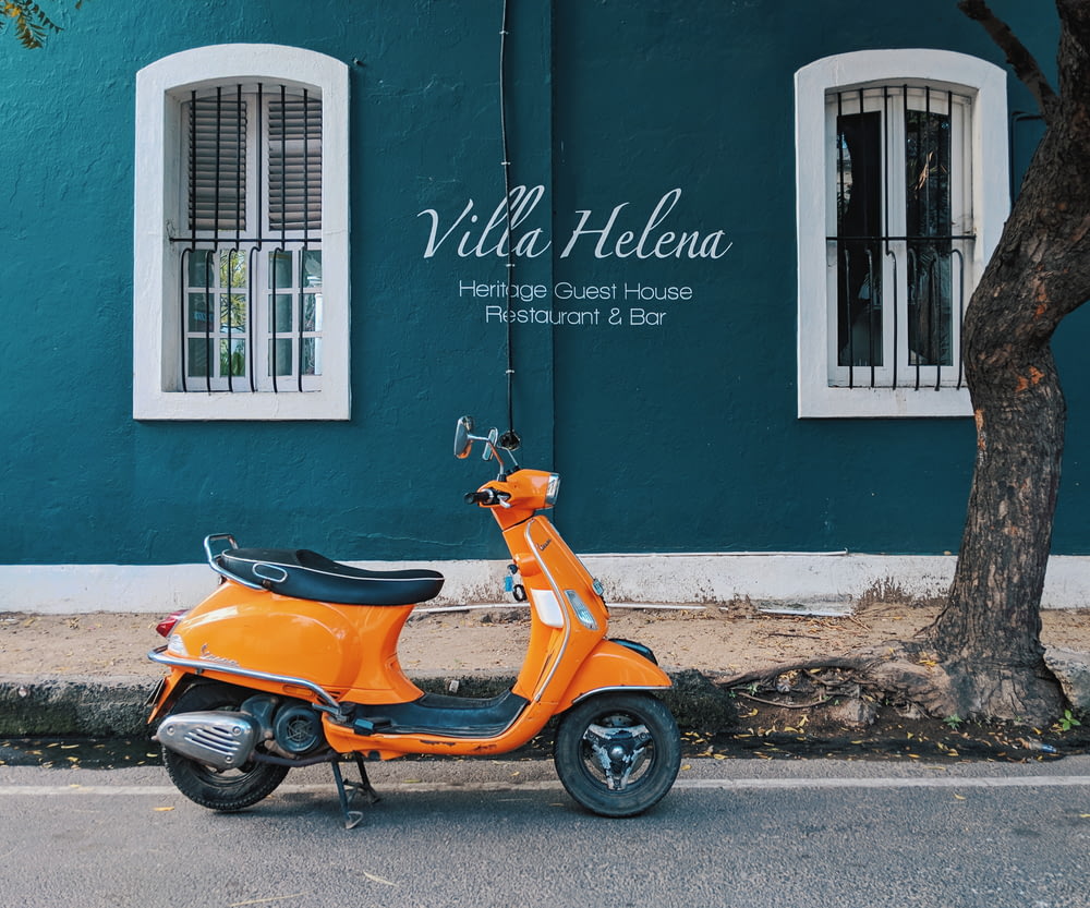 parque de scooters de motor laranja perto do edifício Villa Helena Heritage Guest House