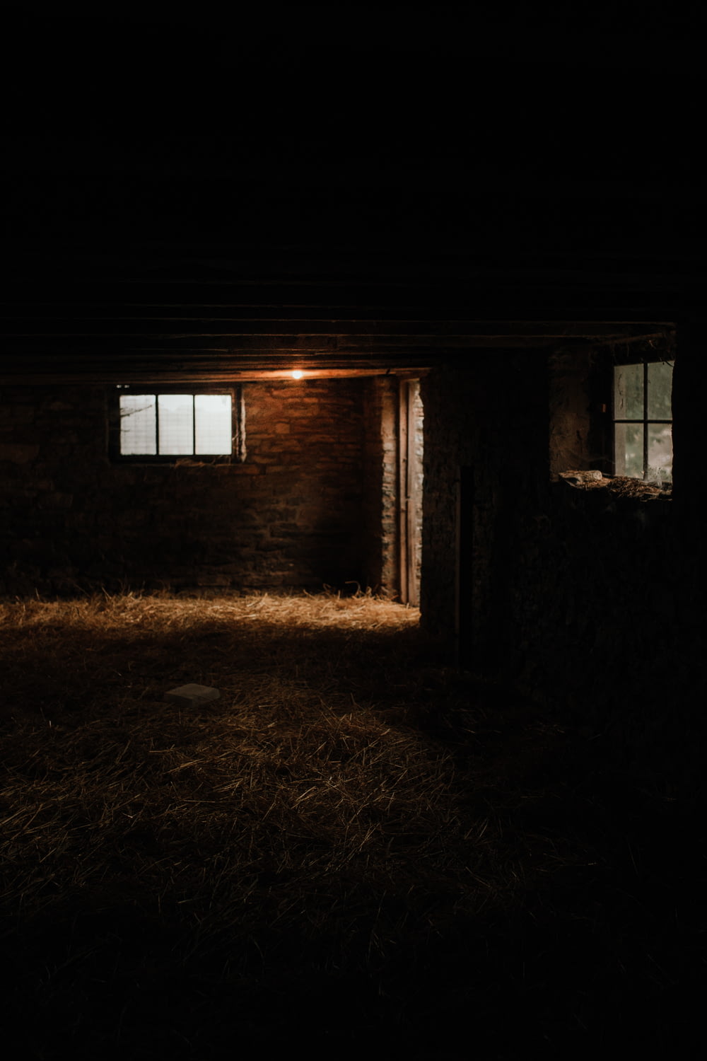 a dark room with a brick wall and a window