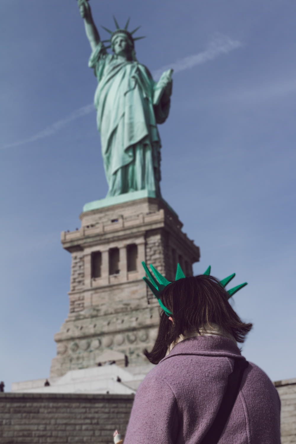 woman standing near Statue of Liberty during daytime