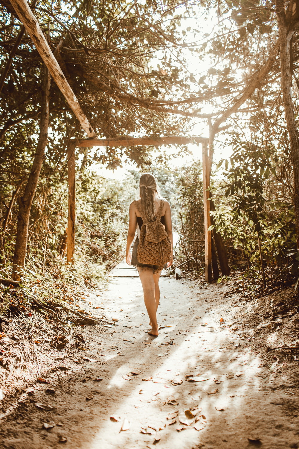 woman standing on tree tunnel at daytime