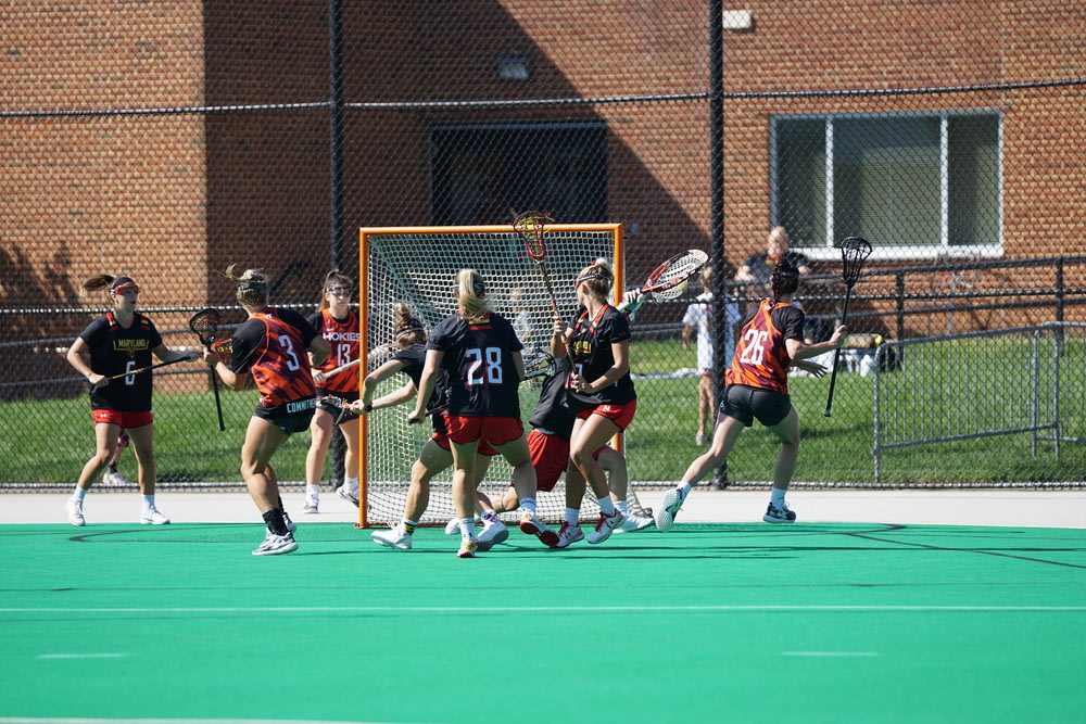 group of woman playing lacrosse during daytime