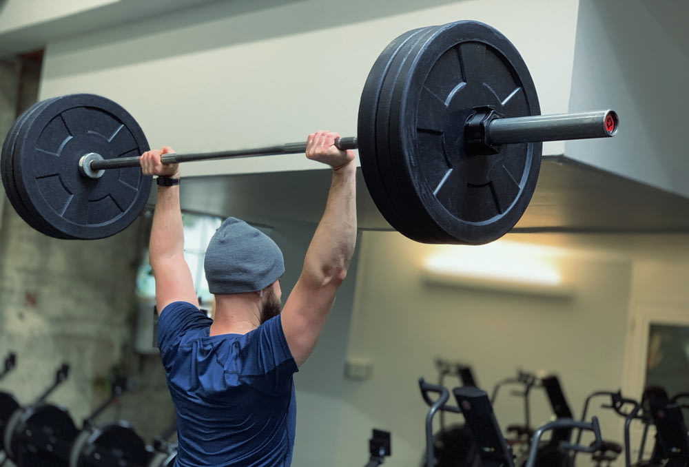 man lifting barbell in gym