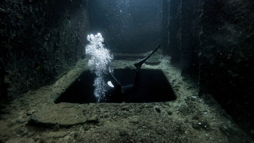 a scuba diver in a deep underwater tunnel
