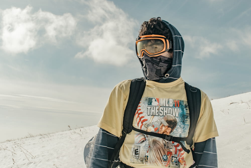 a man wearing a ski mask and goggles standing in the snow