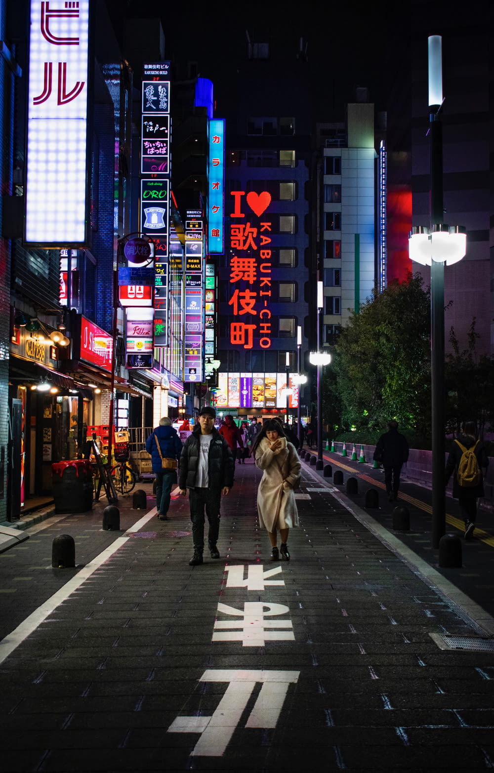 man standing beside woman on street at night