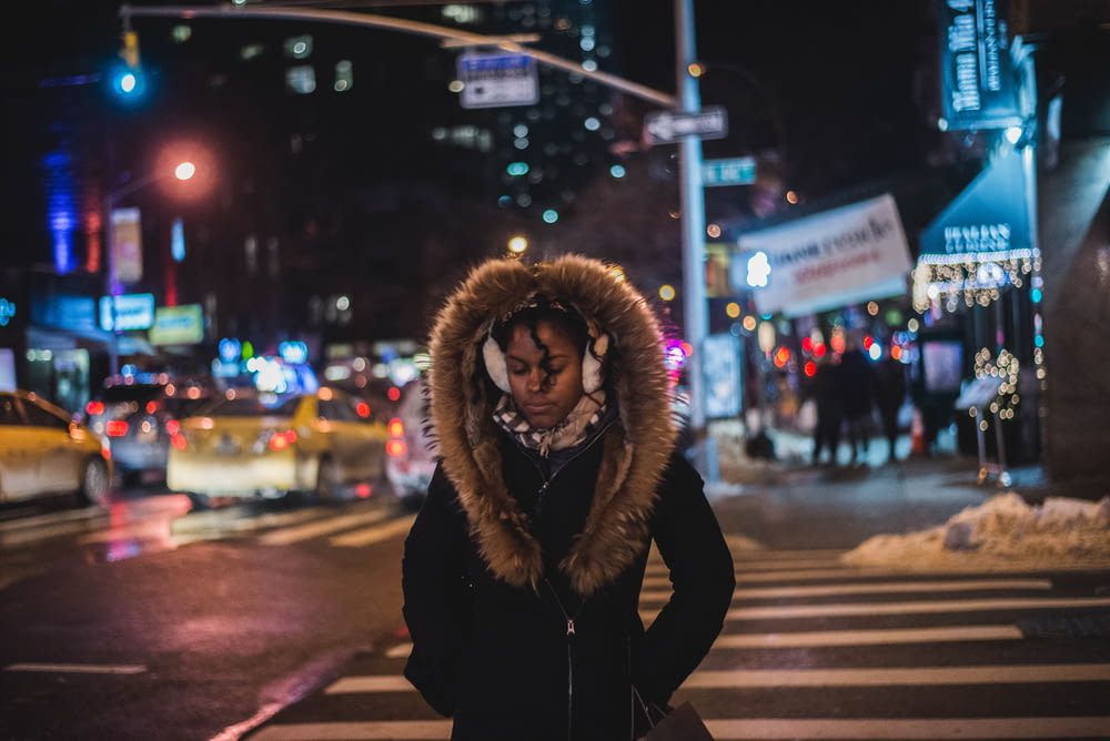 woman standing wearing parka coat at night-time