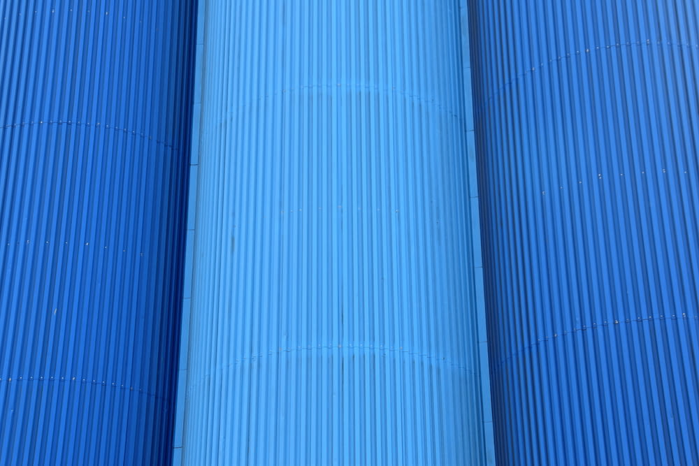 a red fire hydrant in between two blue pipes
