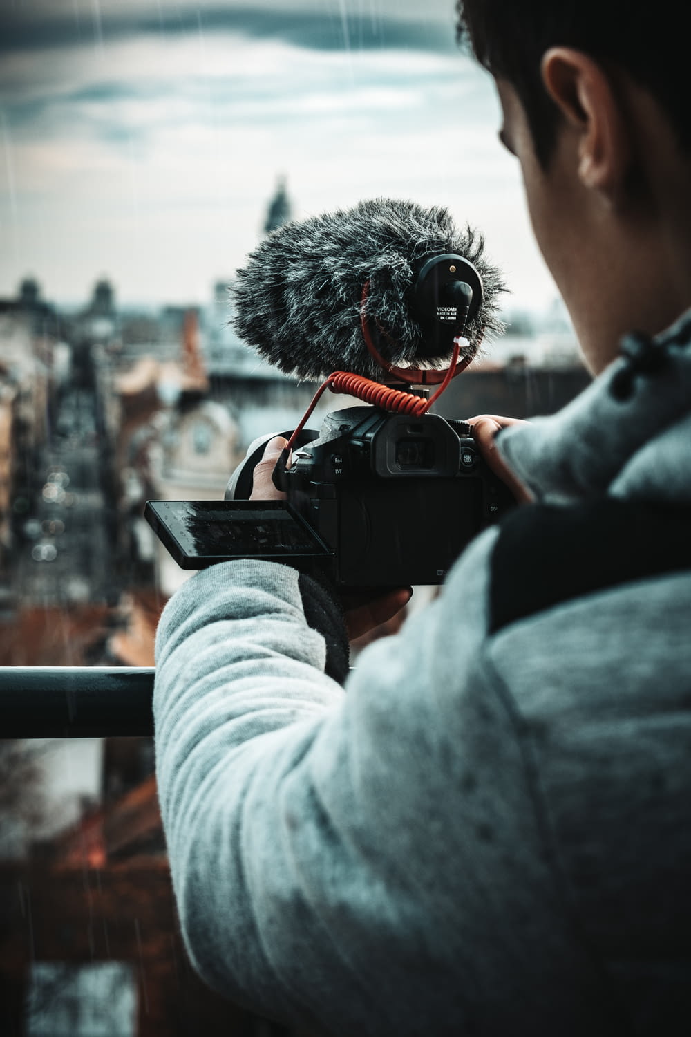 selective focus photography of man using camcorder