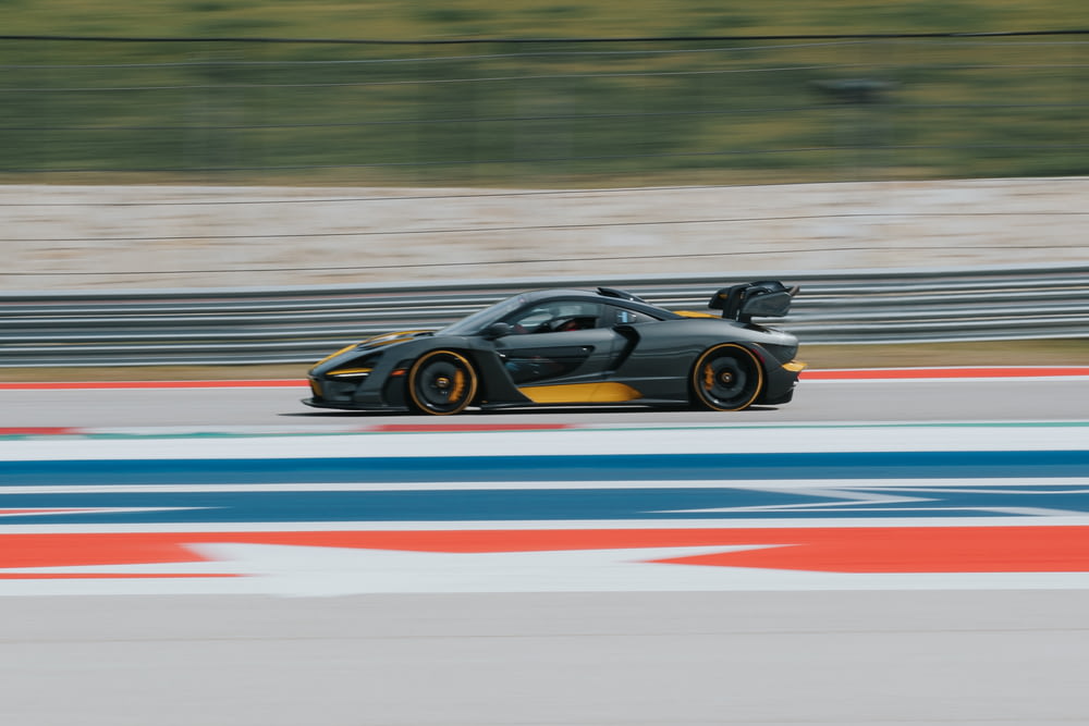 black and yellow sports car speeding on track