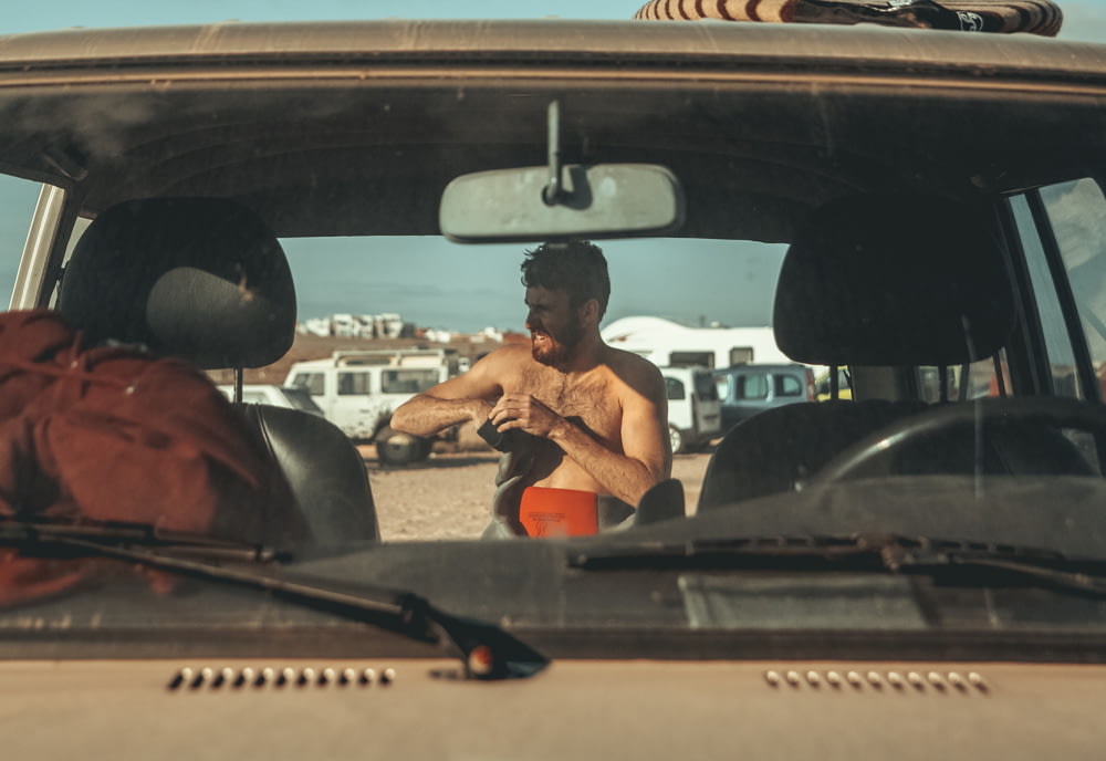 topless man behind vehicle