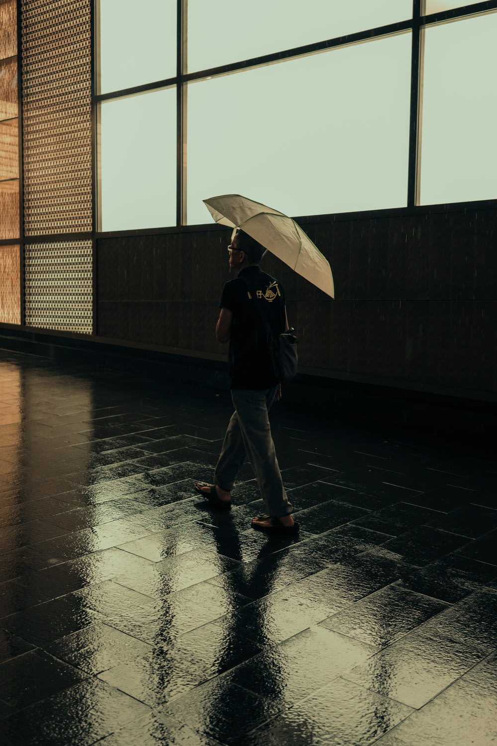 man walking while holding umbrella