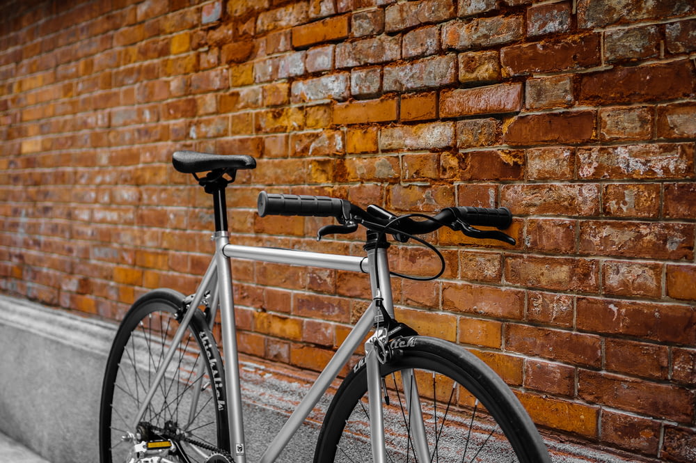 bicicleta gris apoyada en la pared