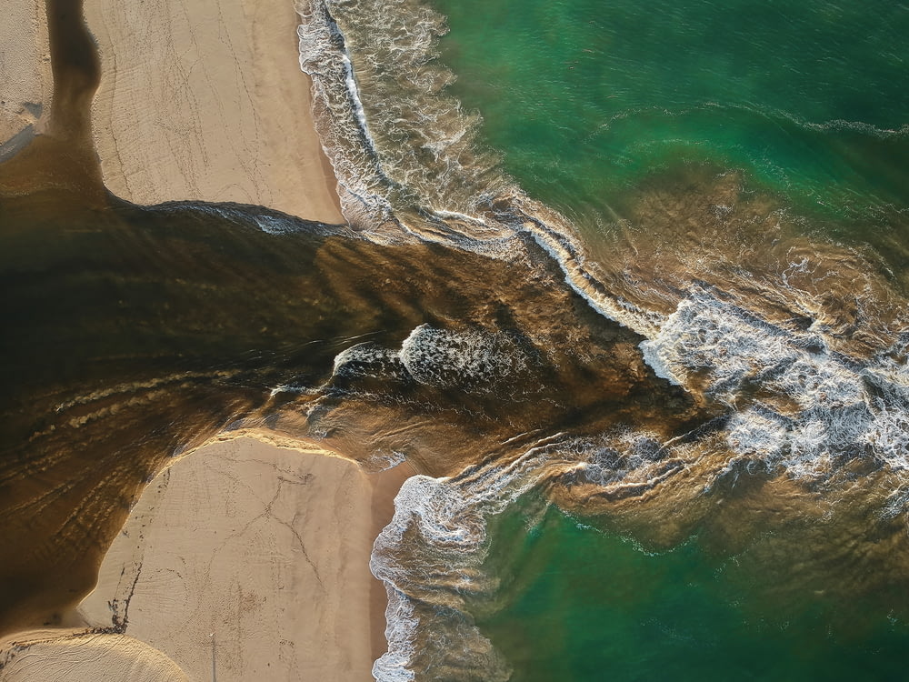 aerial photography of waves splashing on seashore