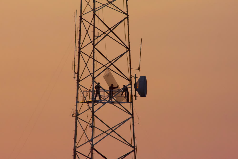 trois personnes debout sur la tour de grue