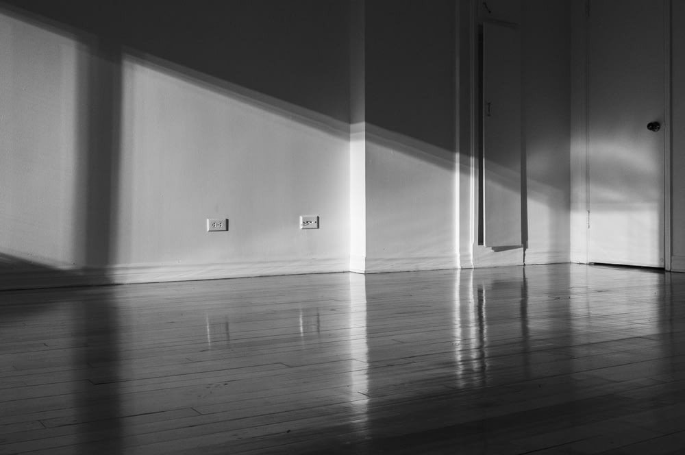 a black and white photo of a room with a door