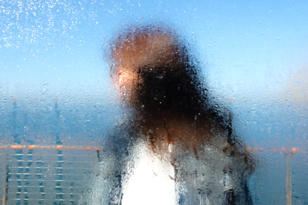 a blurry photo of a person standing in front of a window