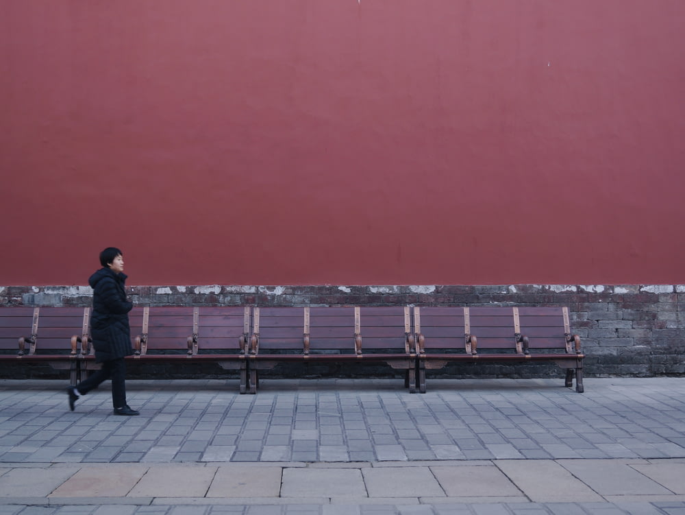 woman walking beside bench