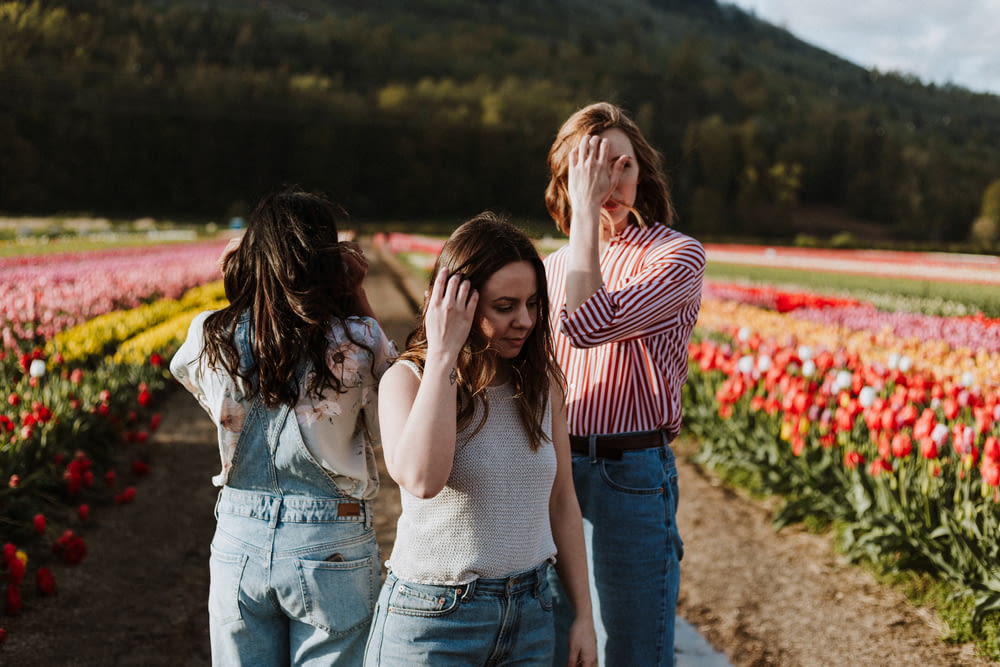 drei Frauen stehen zwischen Blumengarten