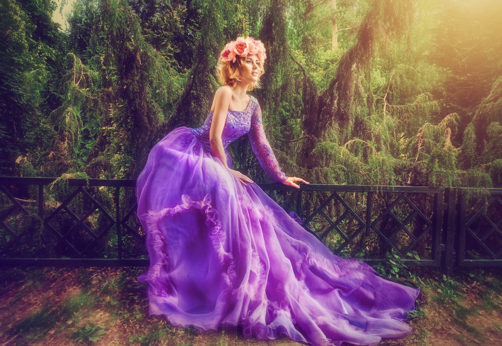 Frau trägt lila Kleid im Wald