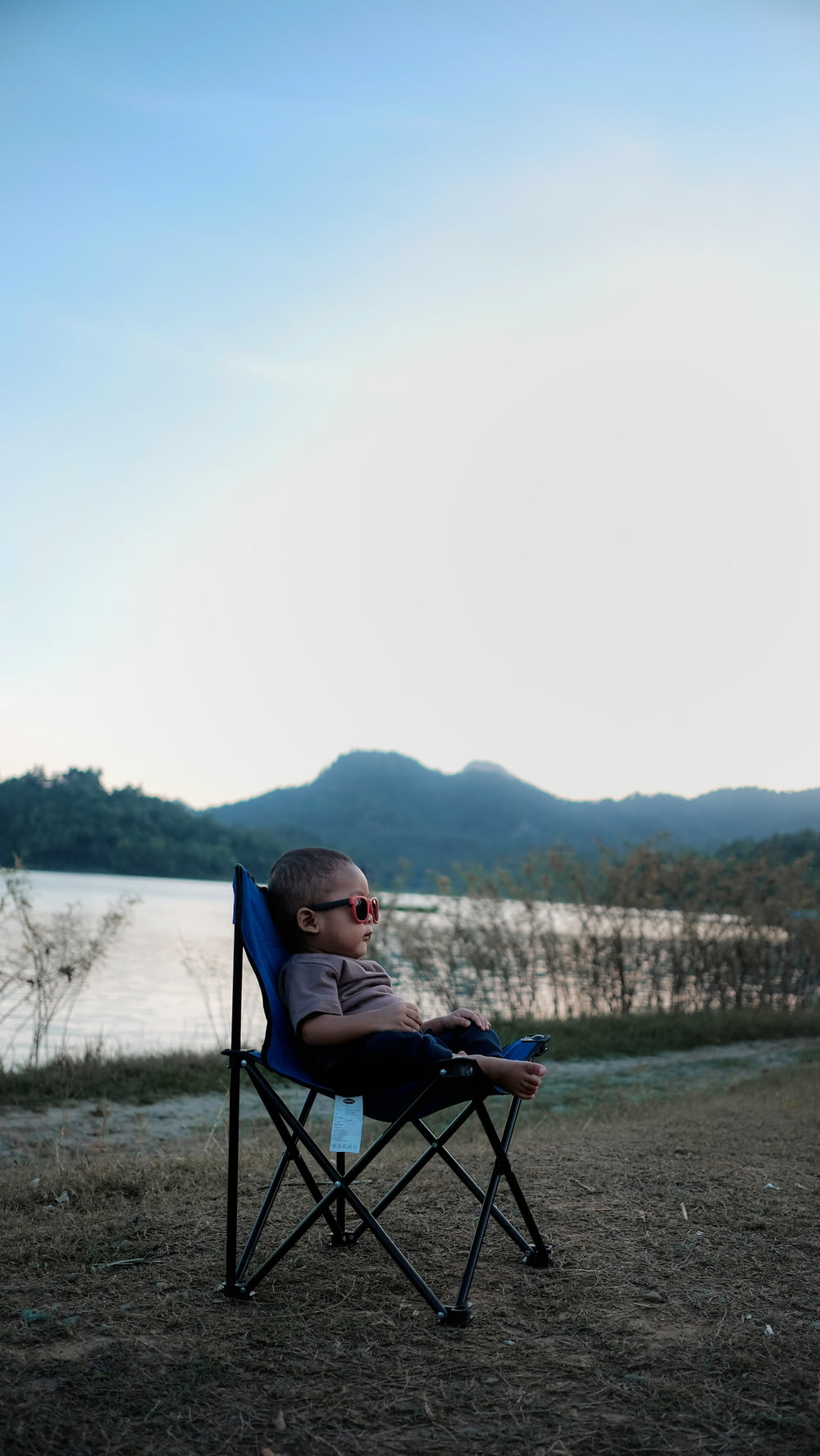 검은 색과 파란색 캠핑 의자에 앉아있는 유아