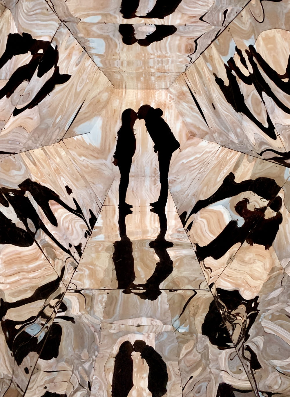 two people kissing in clear glass prism room
