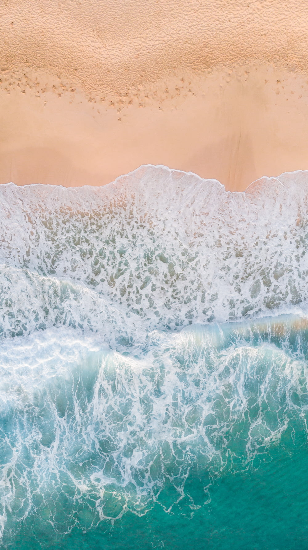 aerial photography of waves splashing on white sand beach