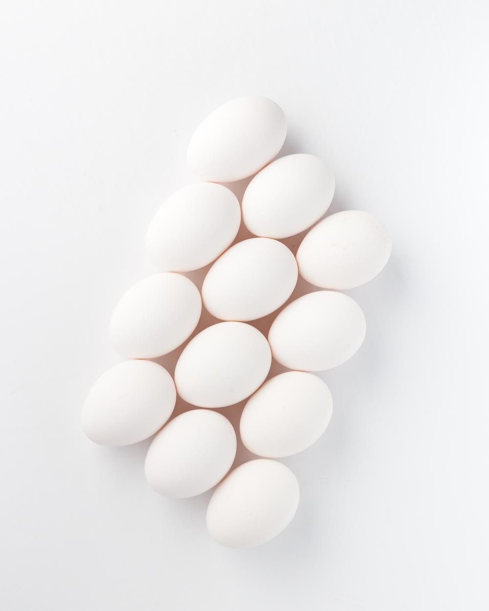 twelve white eggs on white surface