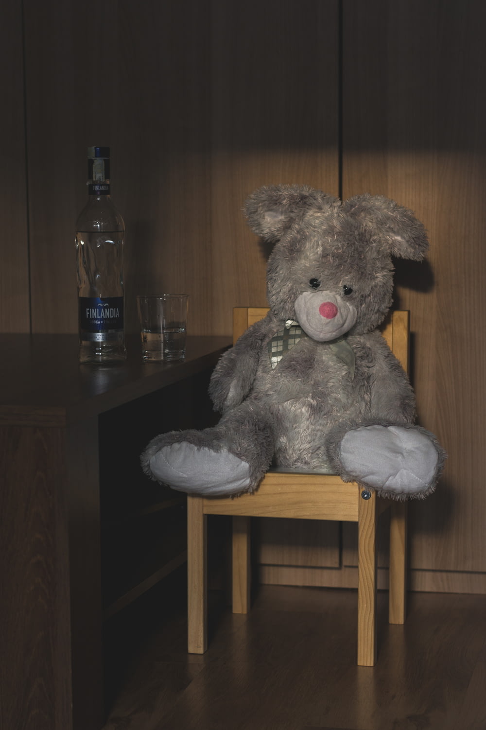 grey bear plush toy on brown wooden chair